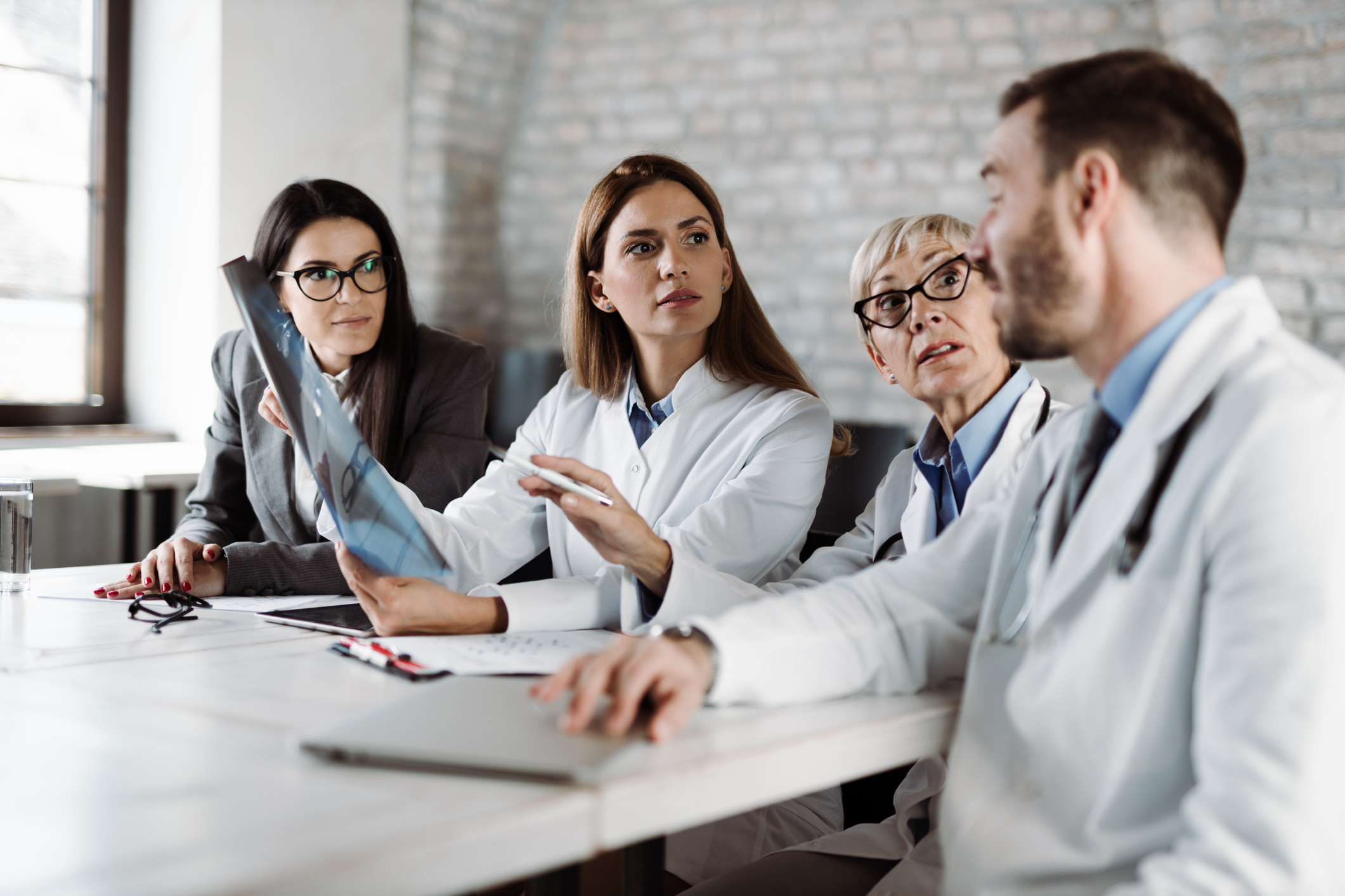 Group of doctors analyzing medical scan with businesswoman  in the hospital