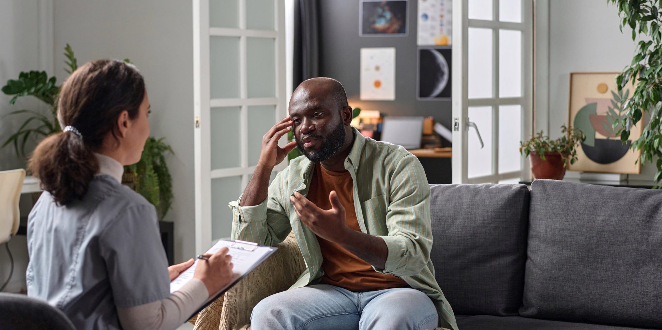 Portrait of adult African American man talking to psychotherapist in one on one session copy space