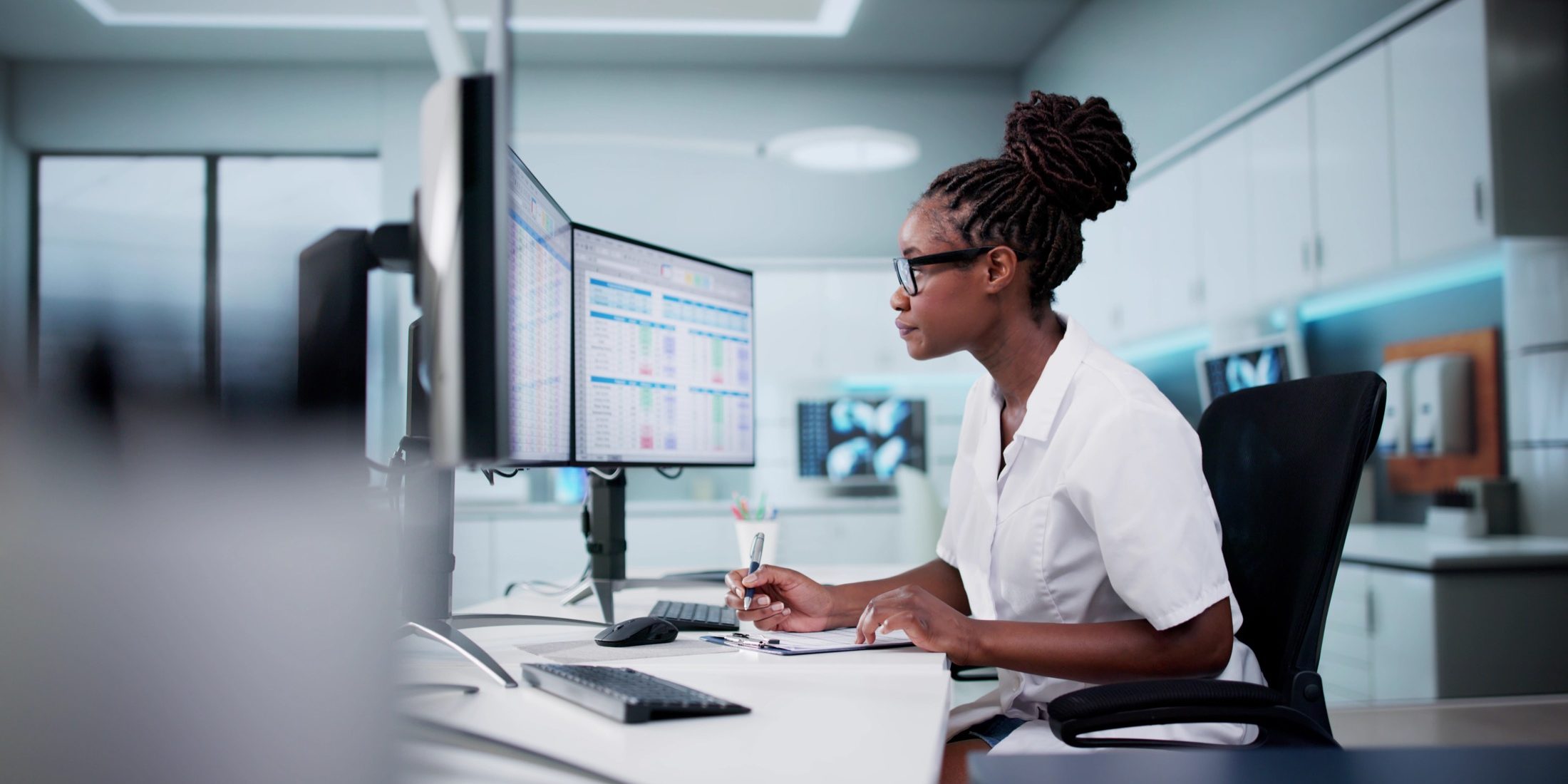 Hospital Doctor Using Spreadsheet For Billing Codes On Desktop
